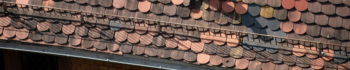 Close-up view of a weathered tile roof and its ridge line