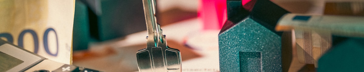 House keys, banknotes and a model house on a desk