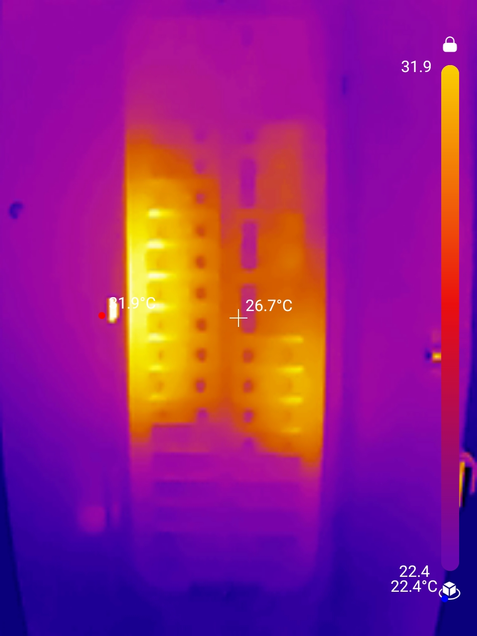 Thermal image of an electrical breaker panel with temperature readings overlaid, showing warm areas in yellow and orange